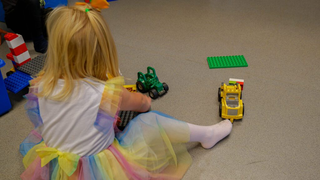 bildet viser en jente som leker med lego