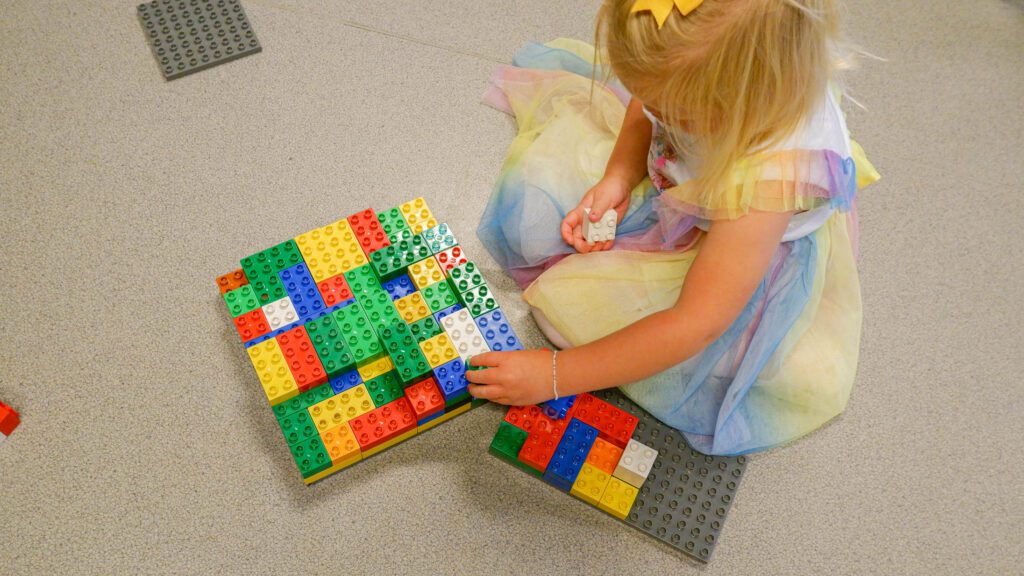 Bildet viser en jente som bygger med lego
